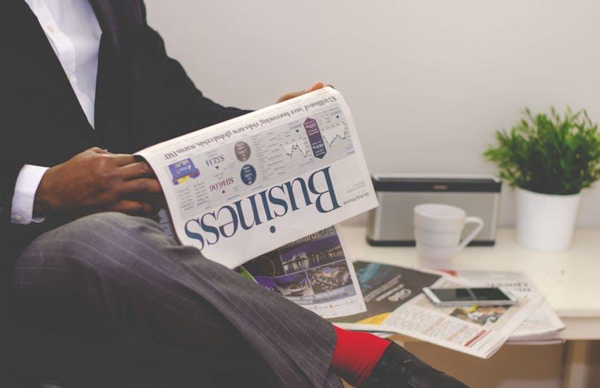 man reading the business section of a newspaper